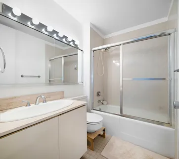 a bathroom with a sink a toilet and shower