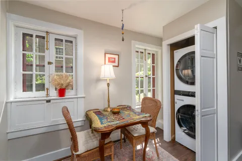 a view of a dining room with furniture a fireplace and windows