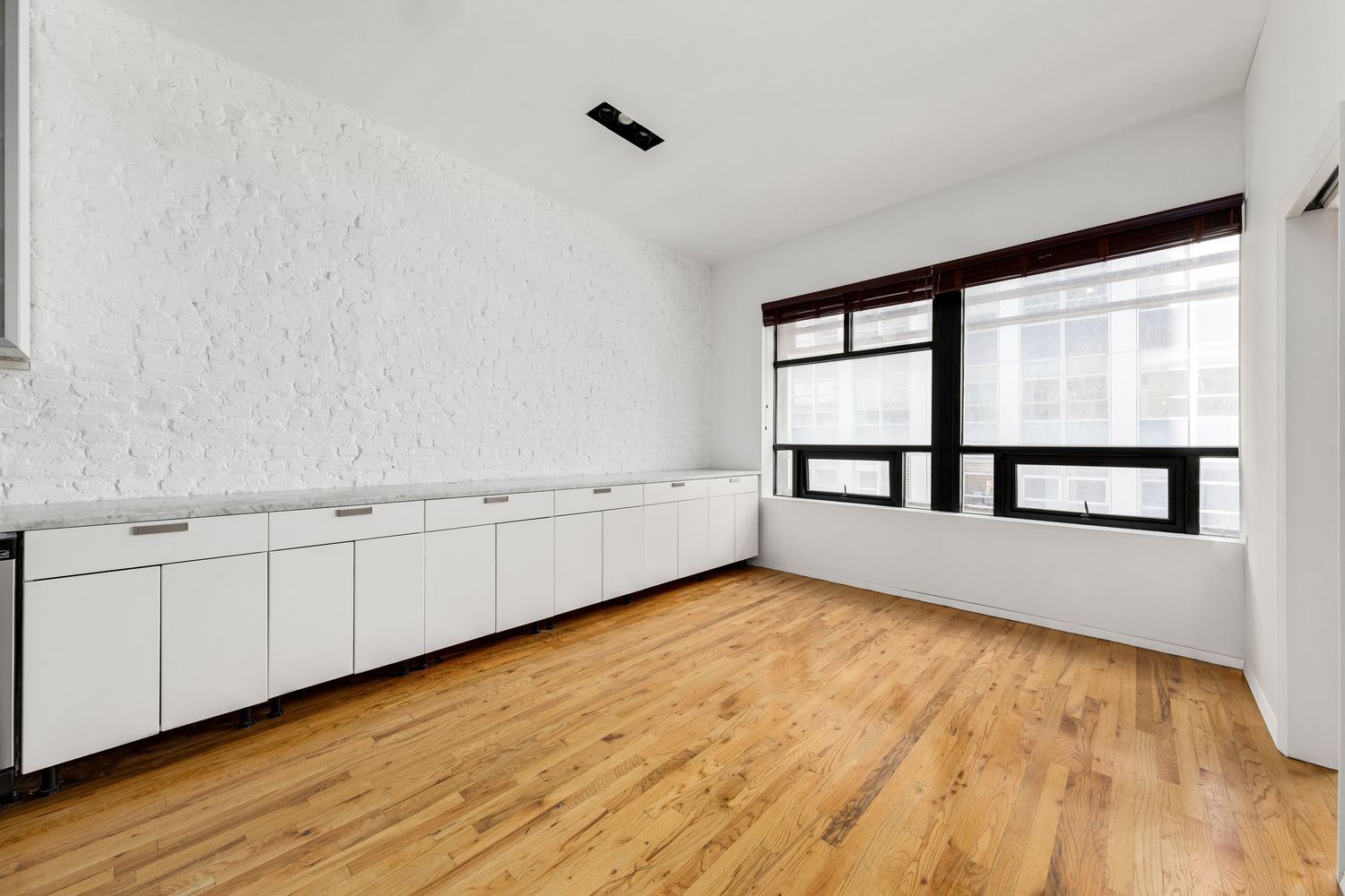 24 Beaver Street Manhattan, NY 10004 - Photo 17 of 25 wooden floor in an empty room with a window