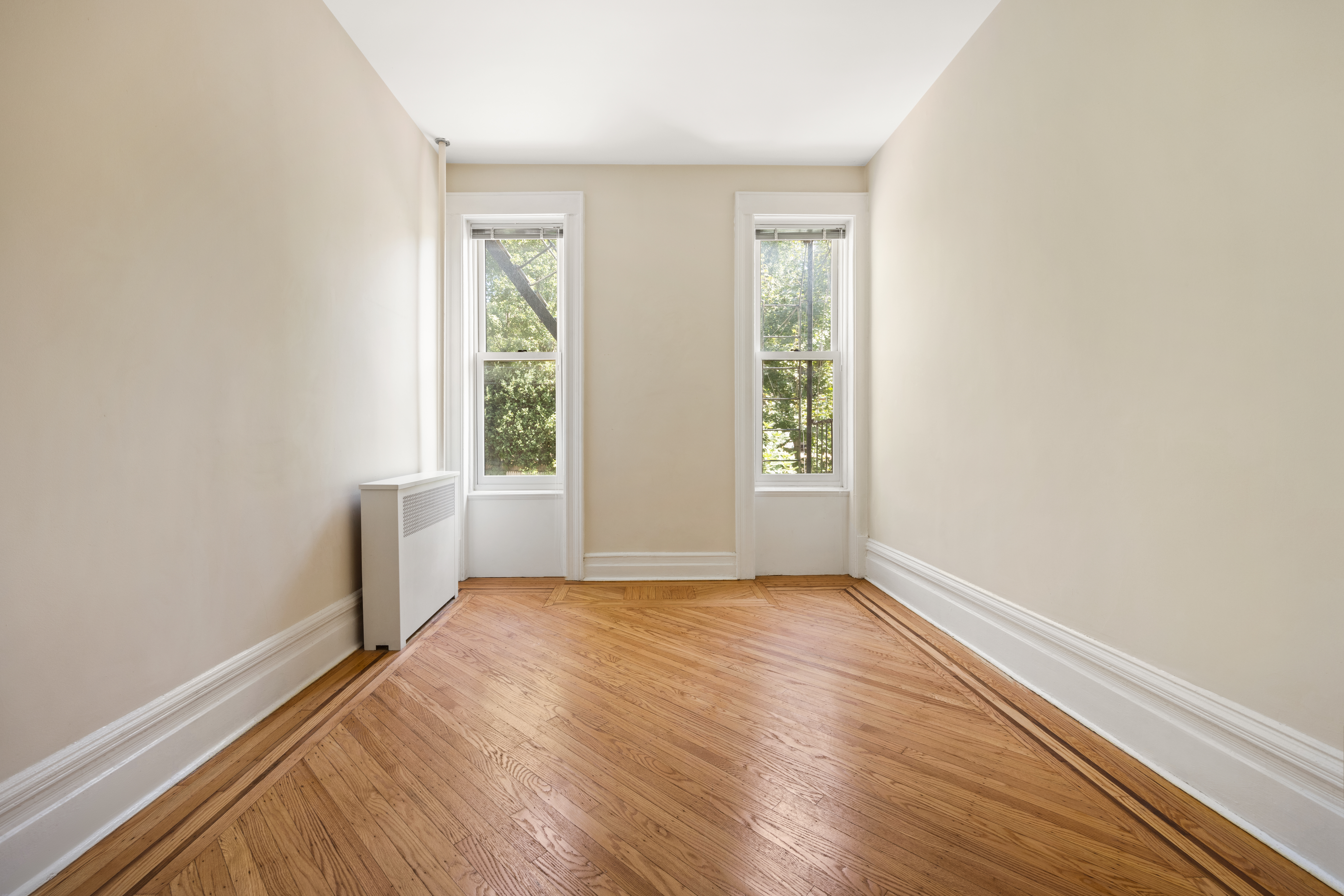 273 Windsor Place Brooklyn, NY 11218 - Photo 7 of 29 an empty room with wooden floor and windows
