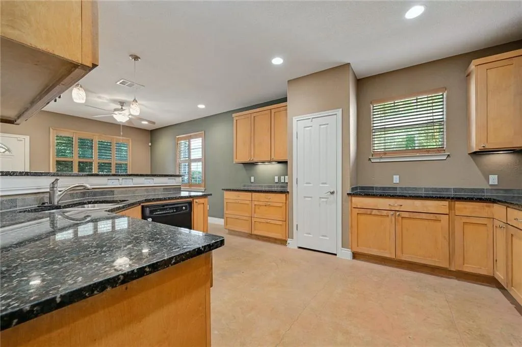 a kitchen with stainless steel appliances granite countertop sink stove refrigerator and cabinets