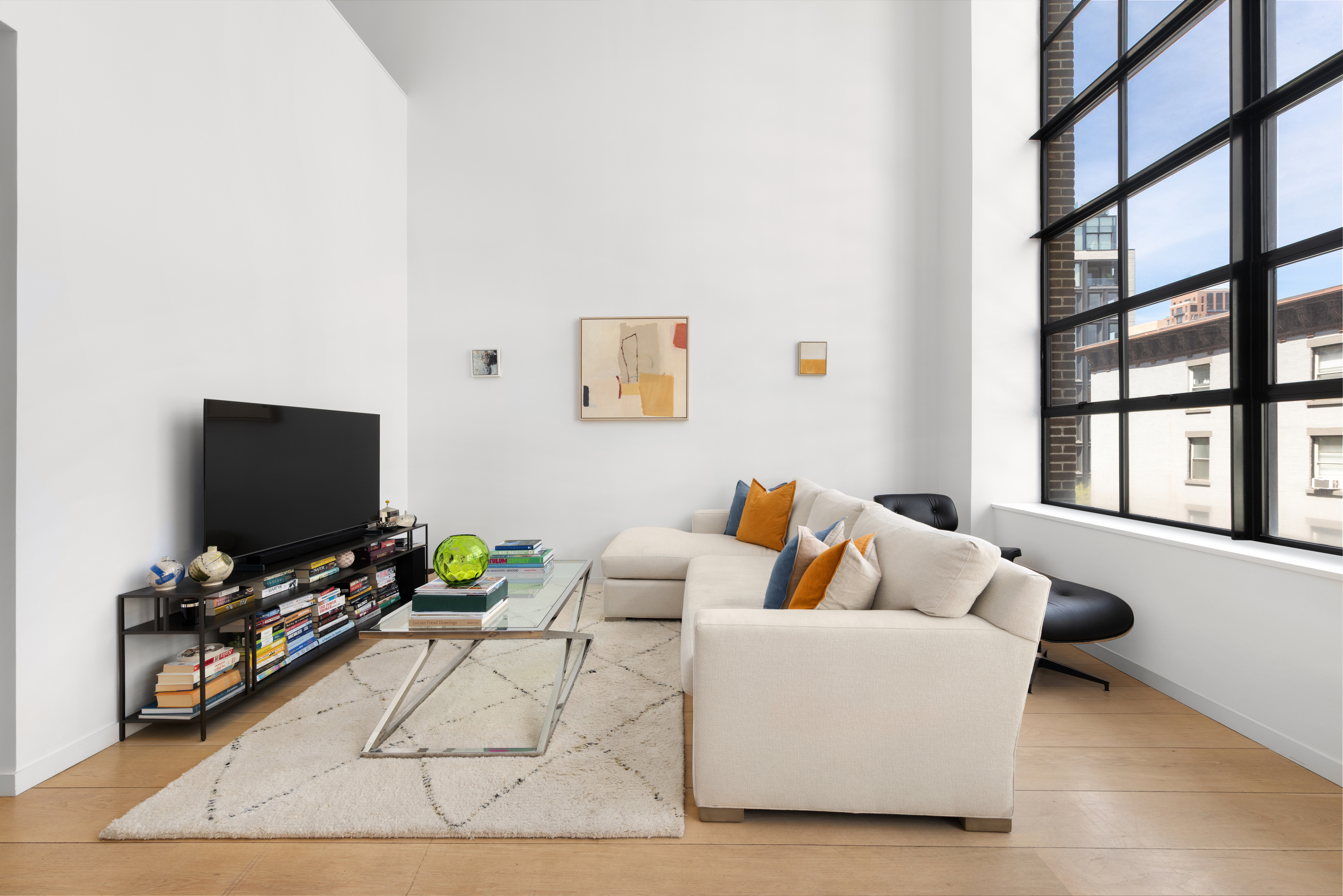 456 West 19th Street, Unit 4/5A Manhattan, NY 10011 - Photo 2 of 15 a living room with furniture and a flat screen tv