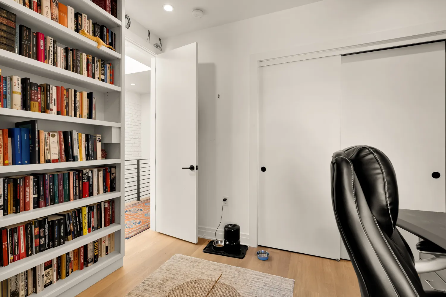 a view of a livingroom with furniture and a book shelf