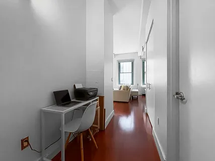 a view of a workspace with furniture and a window