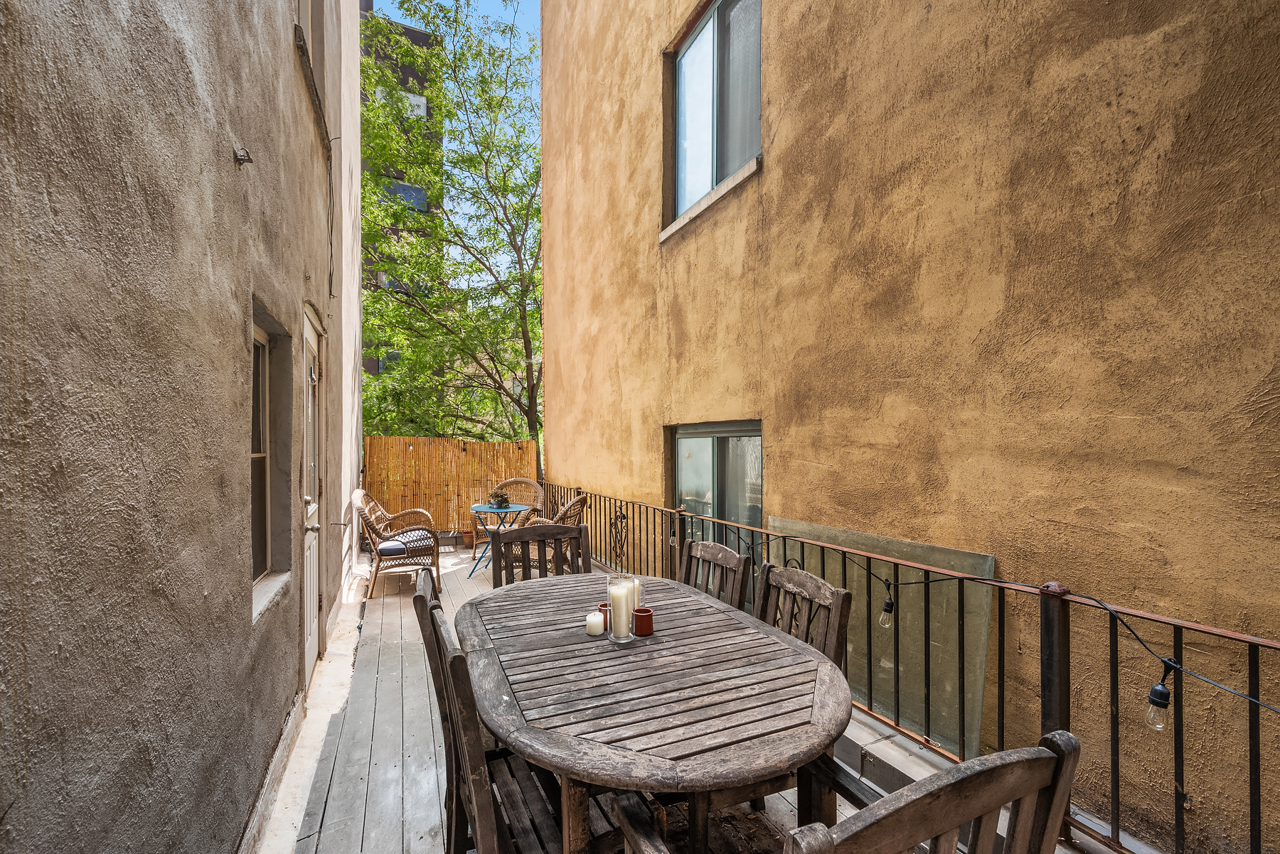 249 Eldridge Street, Unit 4 Manhattan, NY 10002 - Photo 6 of 7 a balcony with wooden floor table and chairs