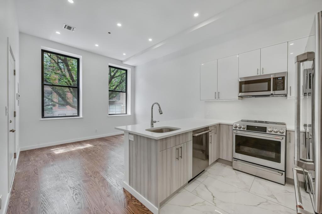 109 President Street, Unit 2 Brooklyn, NY 11231 - Photo 6 of 20 a kitchen with stainless steel appliances granite countertop a sink stove and microwave