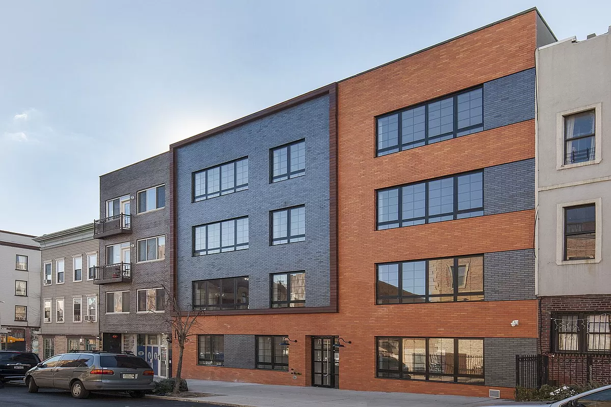 172 Wilson Avenue, Unit PHA Brooklyn, NY 11237 - Photo 13 of 14 a front view of a building with lot of cars and trees