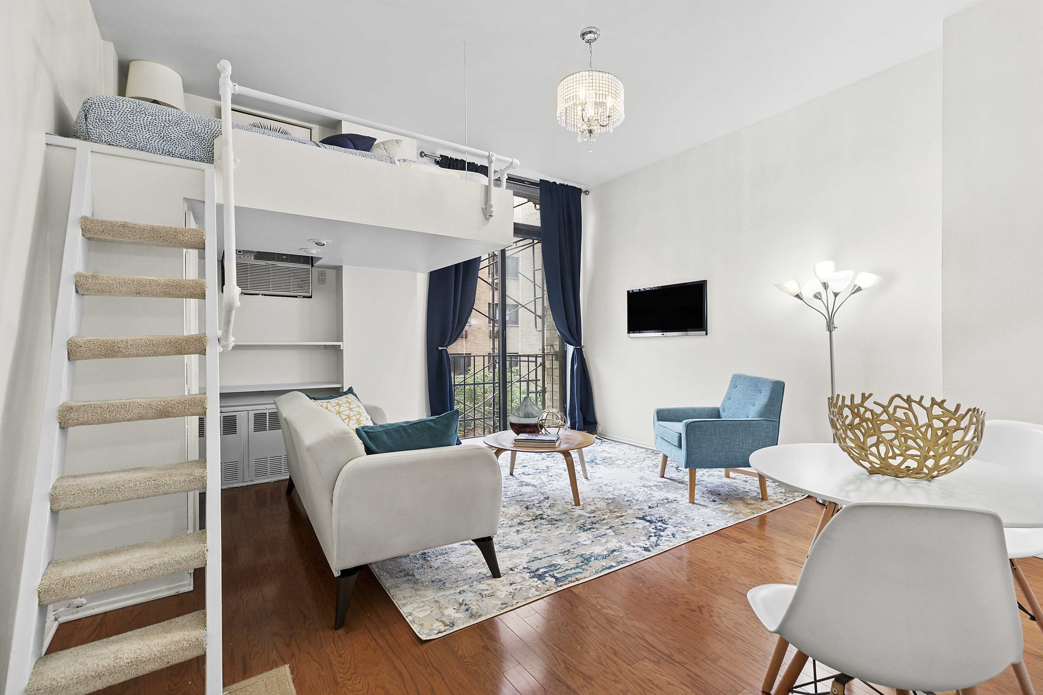215 East 24th Street, Unit 412A Manhattan, NY 10010 - Photo 2 of 6 a living room with furniture wooden floor and a chandelier