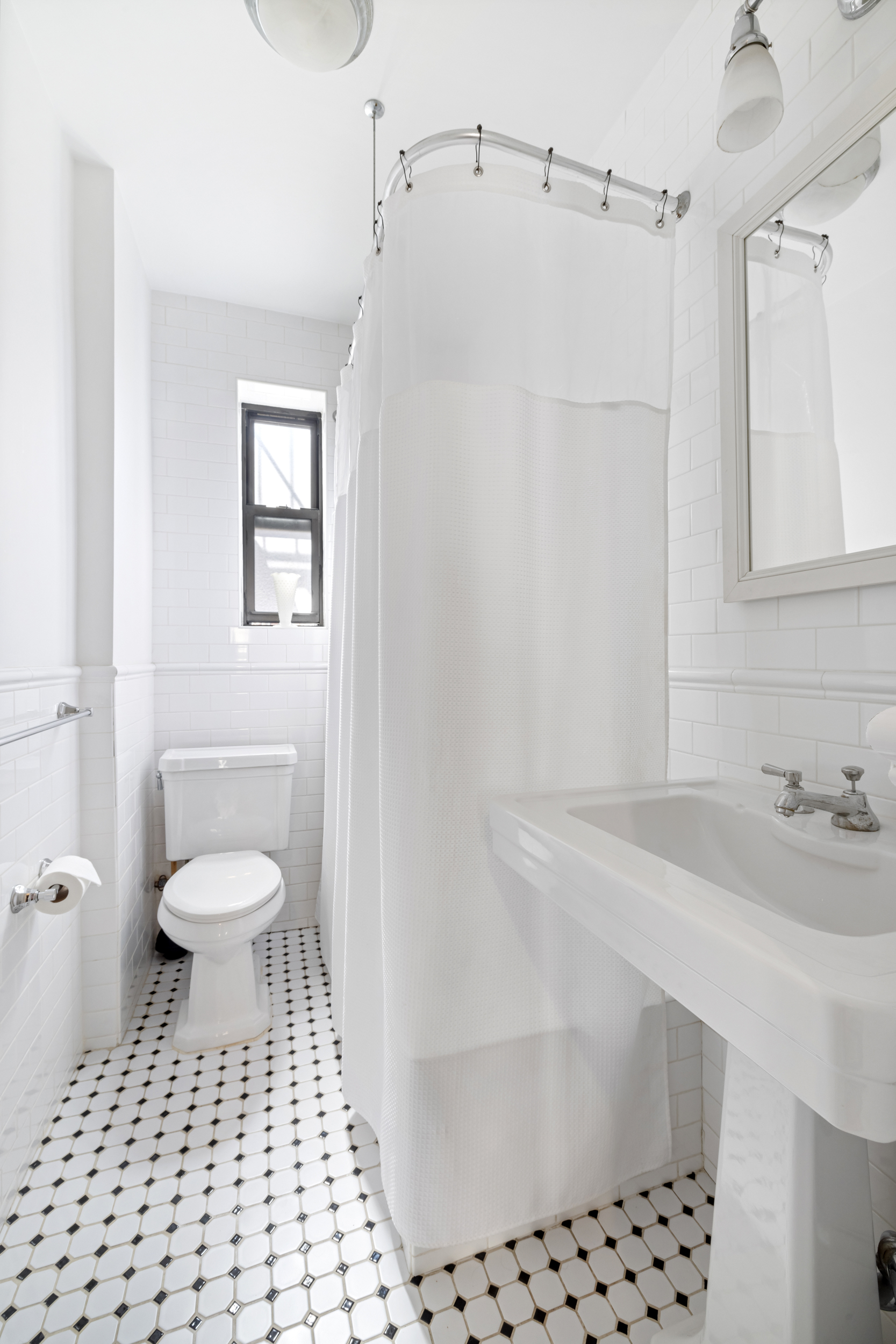 305 East 88th Street, Unit 4A Manhattan, NY 10128 - Photo 6 of 13 a bathroom with a sink toilet a mirror and shower