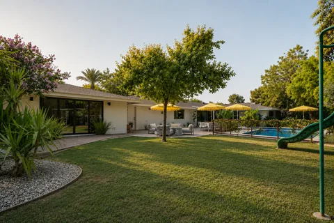 a view of a house with a big yard and sitting area