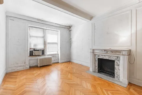 a view of a livingroom with a fireplace and window