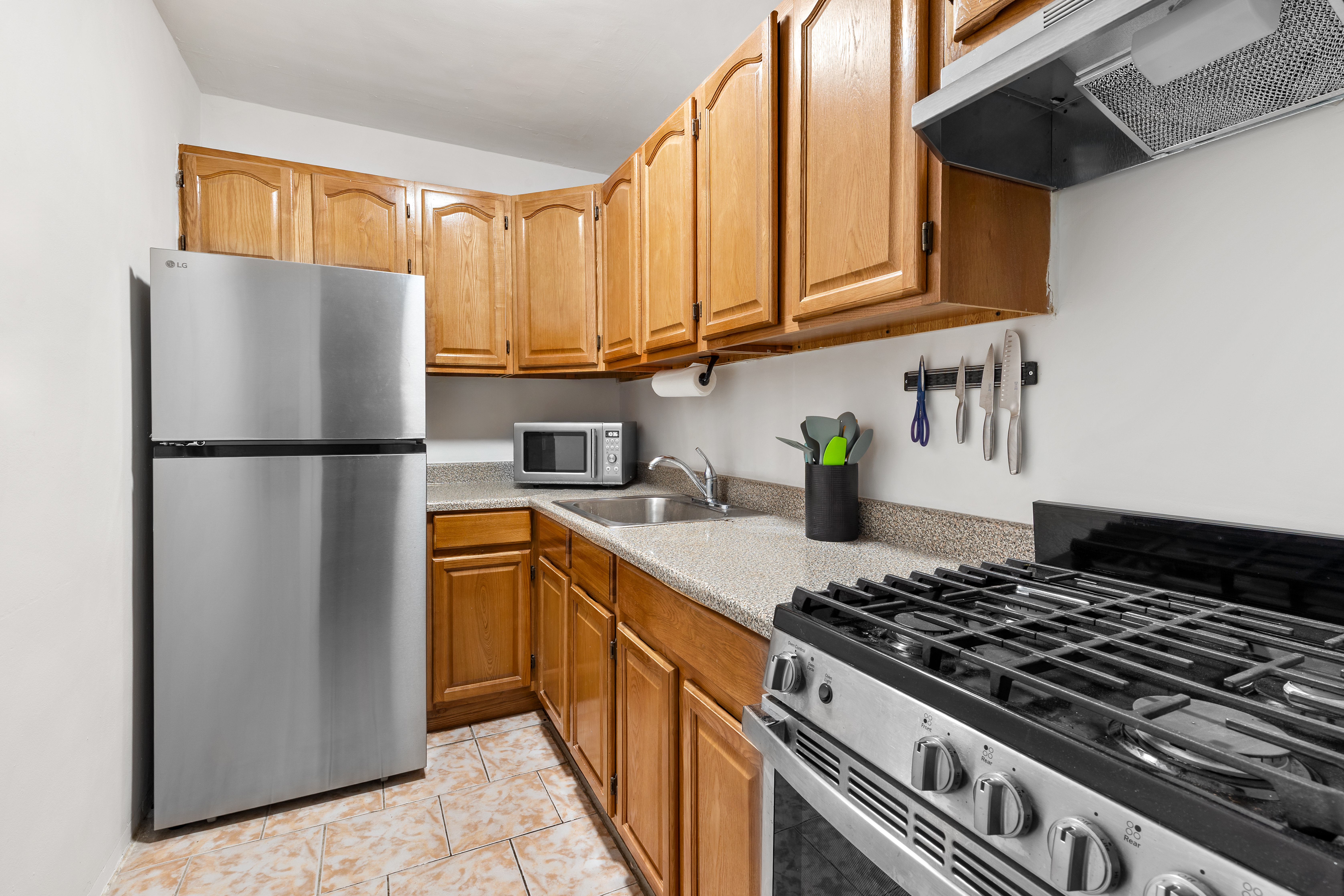 1655 Flatbush Avenue, Unit B210 Brooklyn, NY 11210 - Photo 3 of 5 a kitchen with stainless steel appliances granite countertop a refrigerator stove top oven and sink