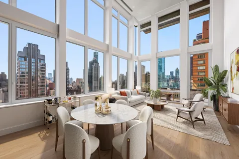 a living room with furniture and floor to ceiling windows