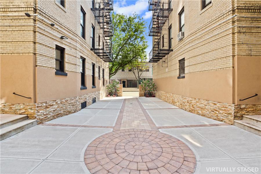 61-09 39th Avenue, Unit 2H Queens, NY 11377 - Photo 8 of 9 a view of a pathway along a building