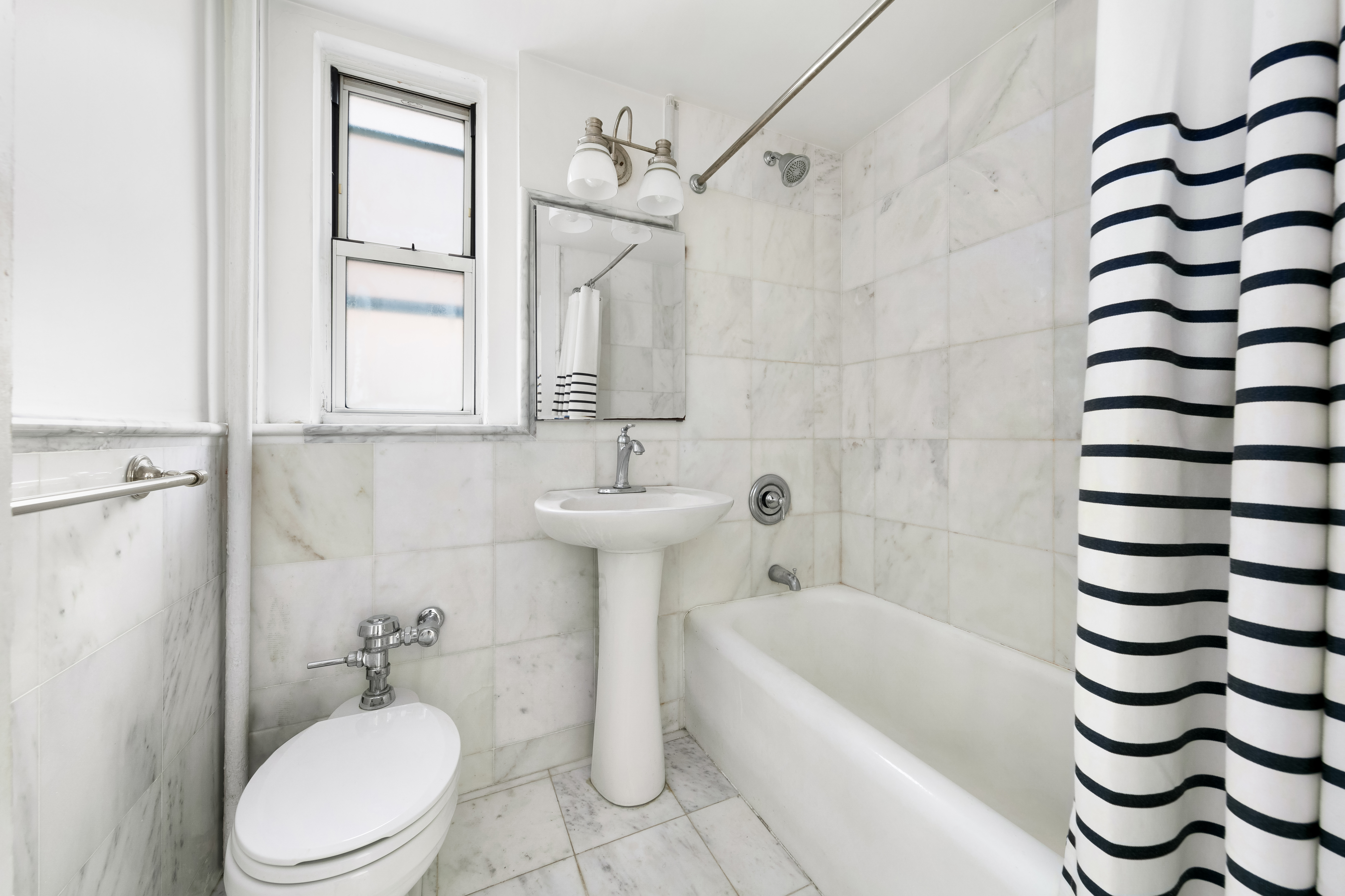 333 East 43rd Street, Unit 910 Manhattan, NY 10017 - Photo 4 of 13 a bathroom with a sink a toilet and a bathtub