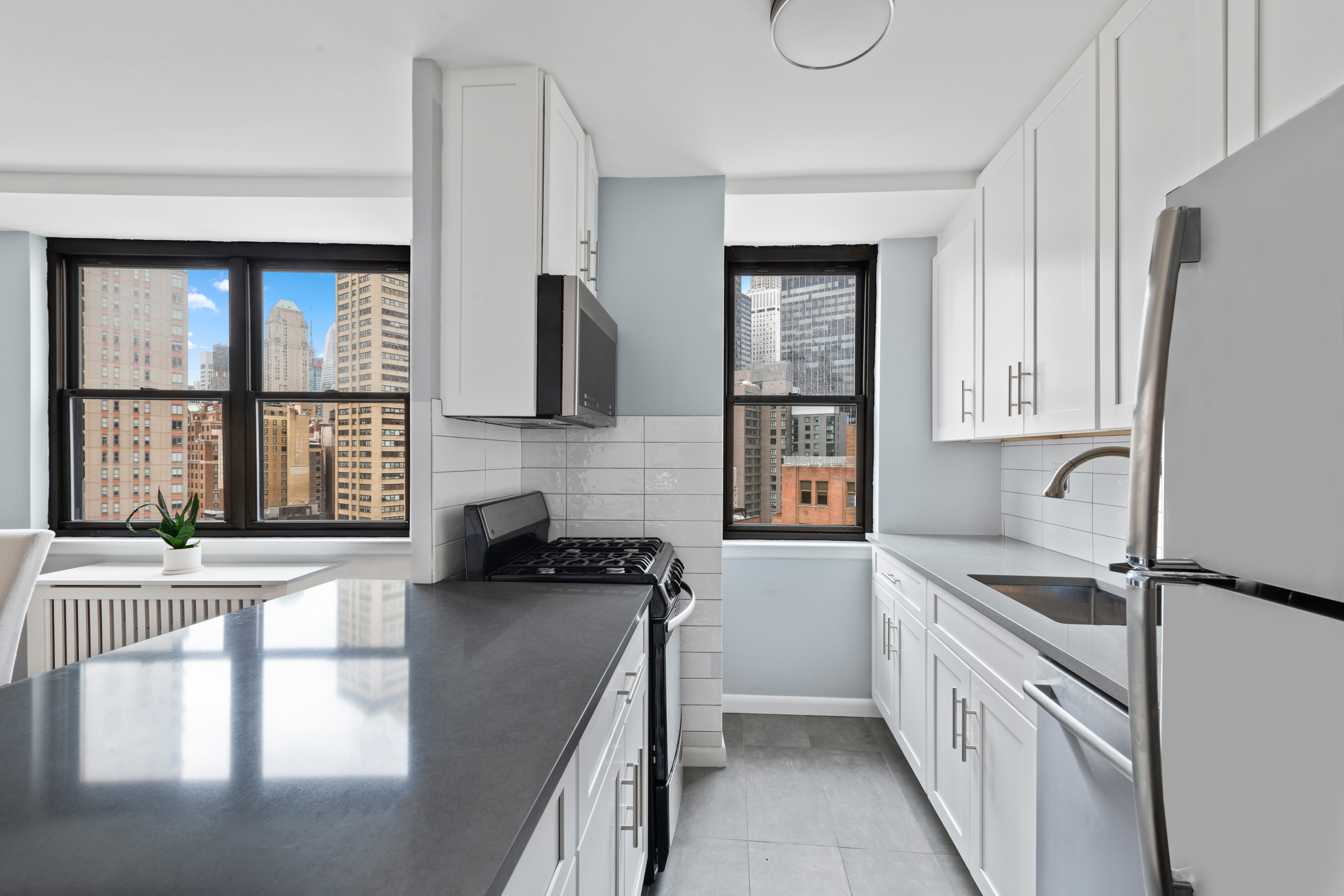 225 East 36th Street, Unit 18M Manhattan, NY 10016 - Photo 3 of 9 a kitchen with stainless steel appliances granite countertop a sink stove and cabinets