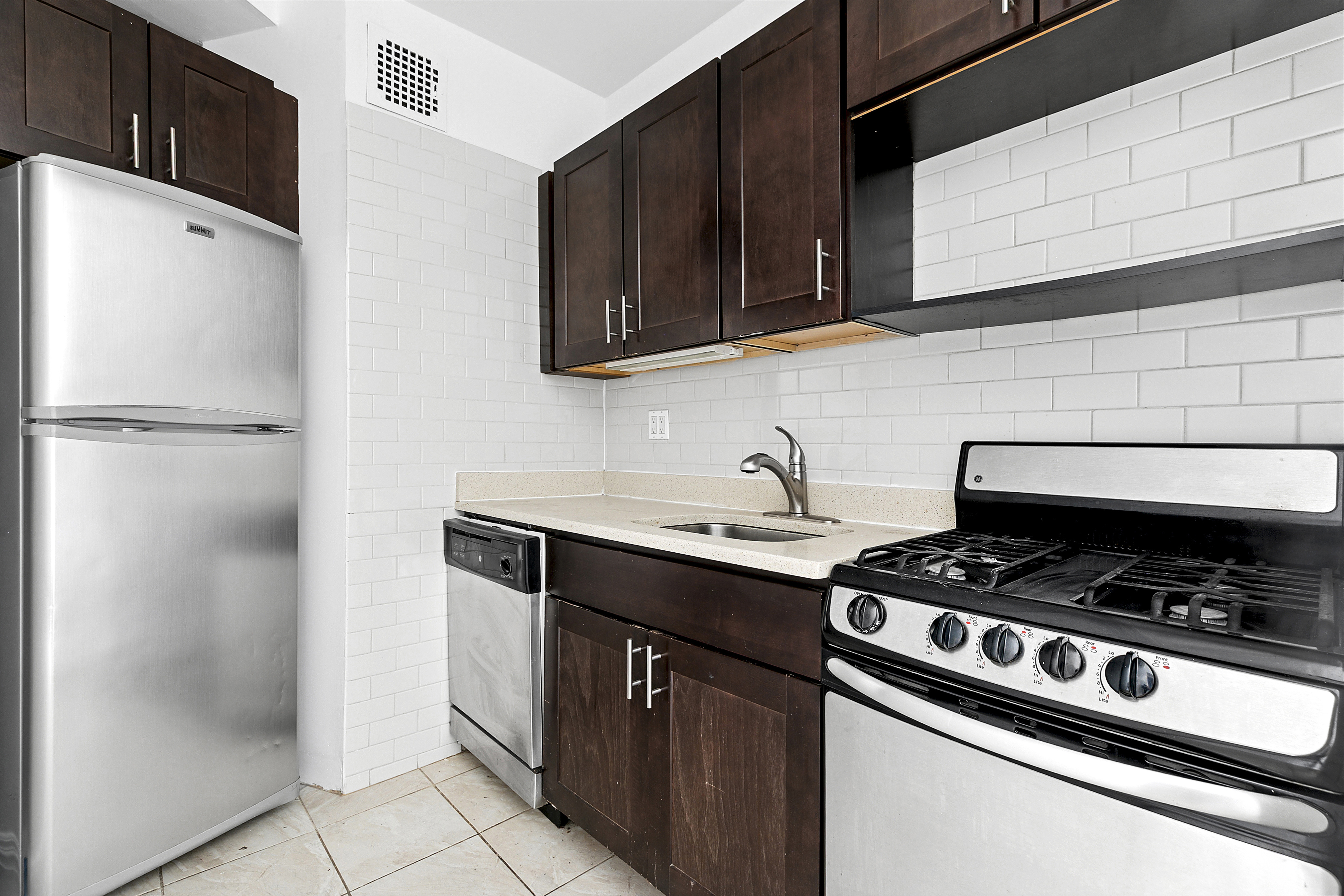643 9th Avenue, Unit 4A Manhattan, NY 10036 - Photo 2 of 5 a kitchen with stainless steel appliances granite countertop a sink stove and refrigerator