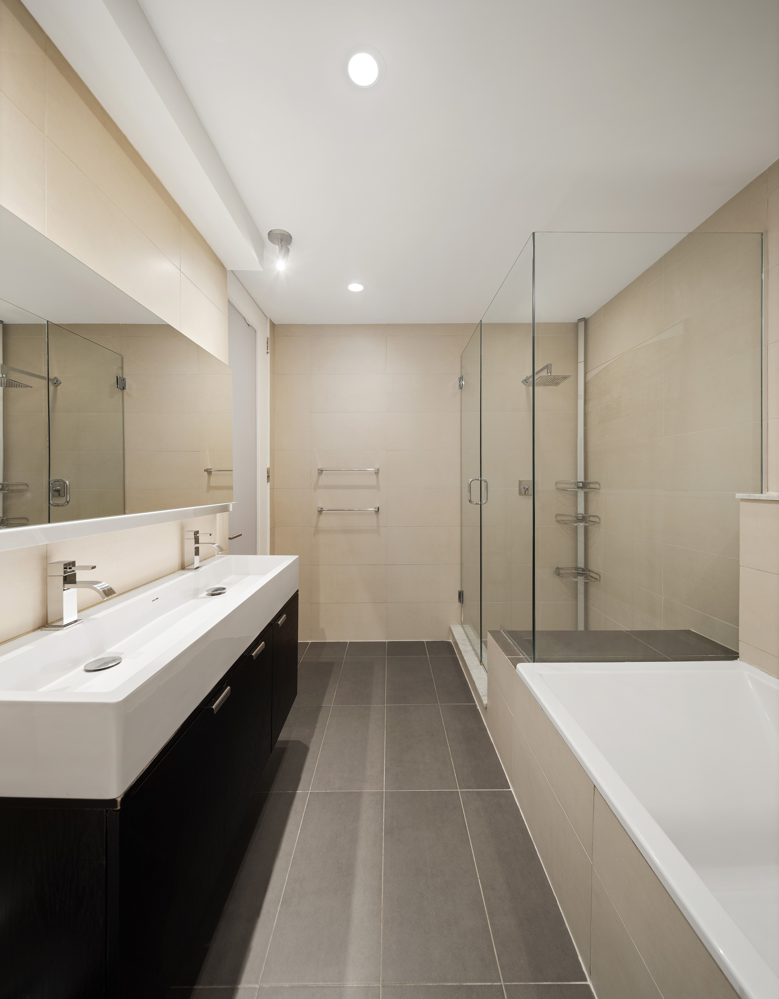 176 Broadway, Unit 3C Manhattan, NY 10038 - Photo 5 of 8 a large bathroom with a double vanity sink and mirror