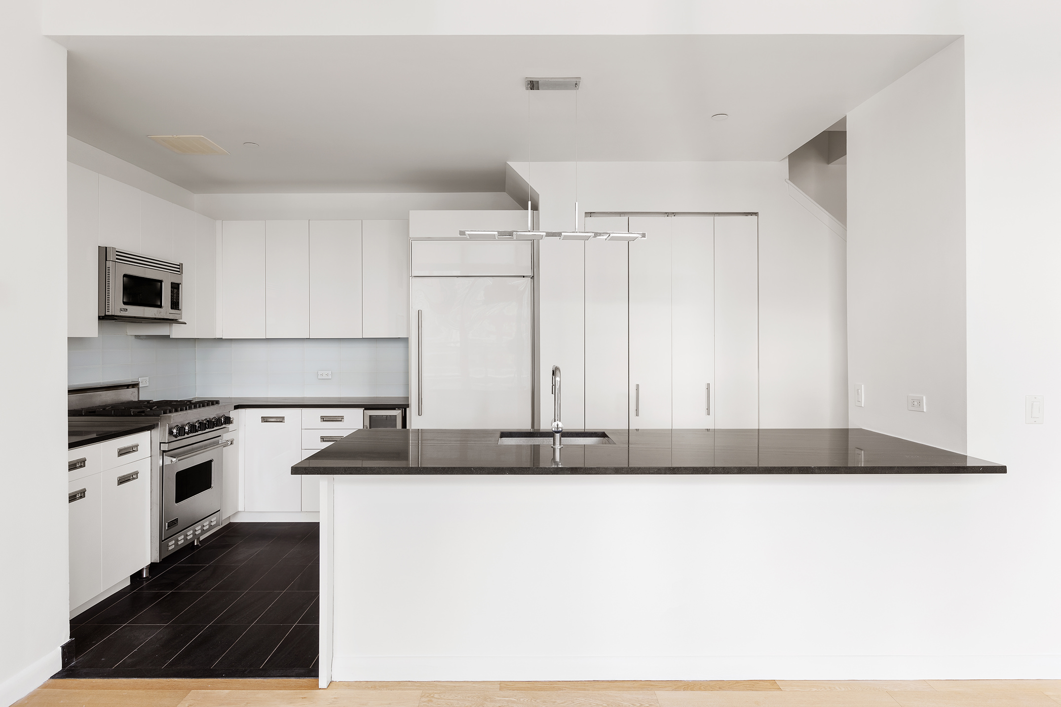 46-30 Center Boulevard, Unit PH8 Queens, NY 11109 - Photo 6 of 32 a kitchen with granite countertop a stove a sink and a microwave