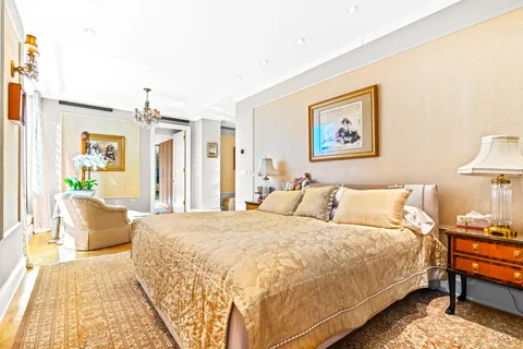 a bedroom with a bed a couch and a potted plant