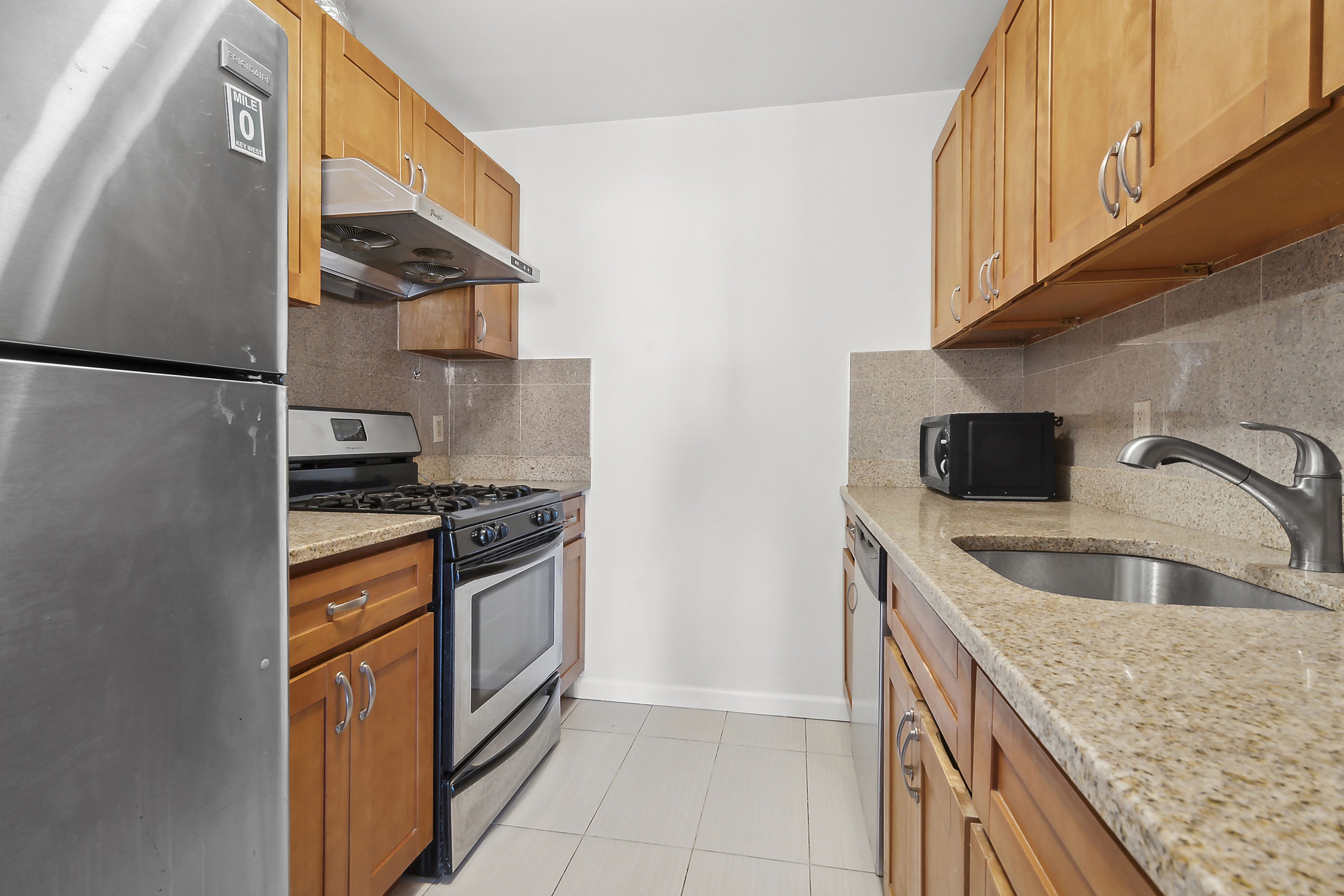 63-14 Queens Boulevard, Unit 7P Queens, NY 11377 - Photo 4 of 10 a kitchen with granite countertop a sink and a stove