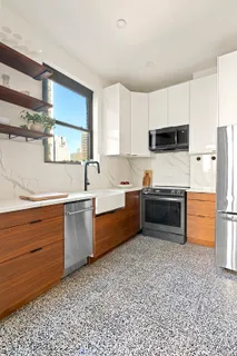 a kitchen with stainless steel appliances a refrigerator sink and cabinets