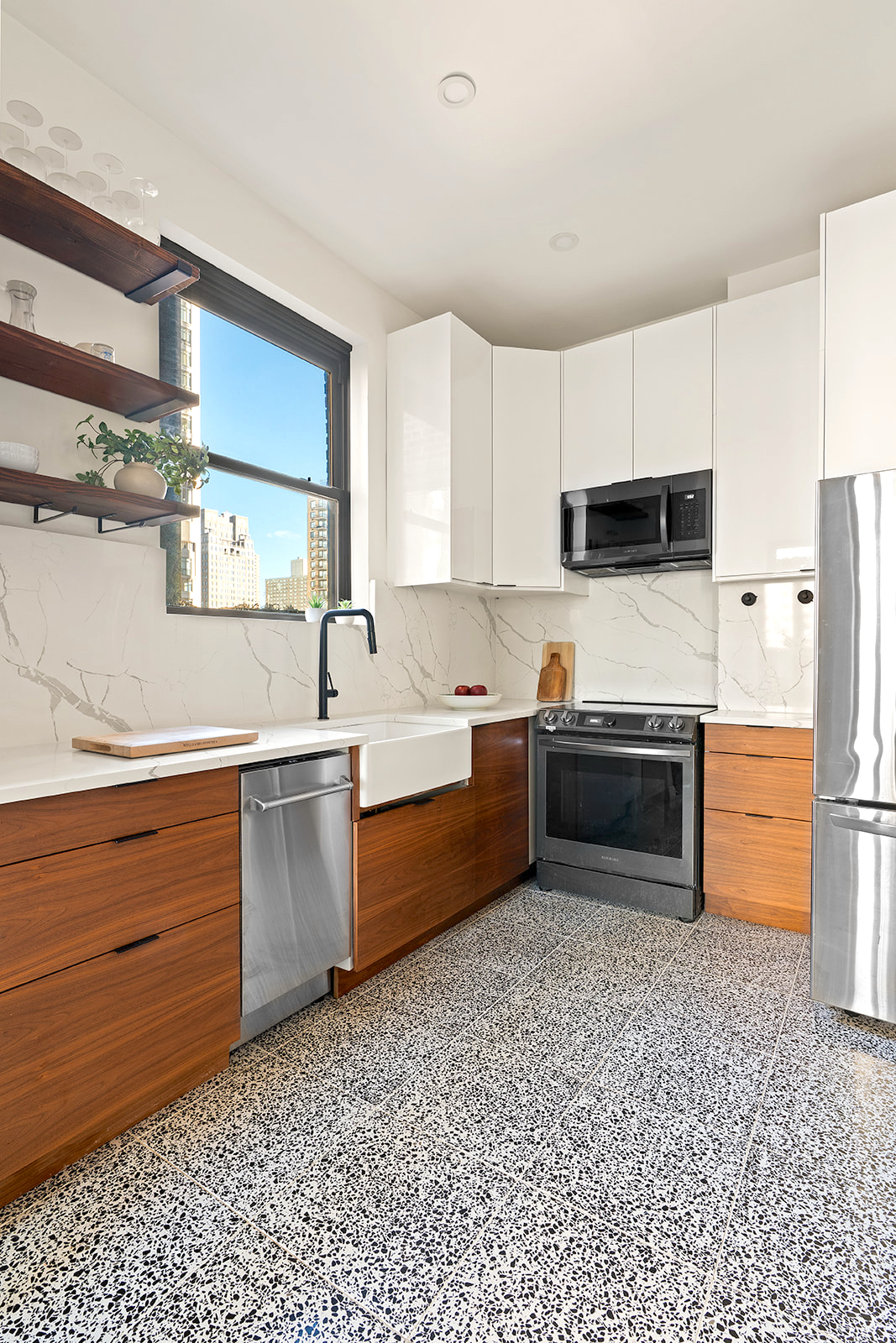 151 East 83rd Street, Unit PHC Manhattan, NY 10028 - Photo 7 of 16 a kitchen with stainless steel appliances a refrigerator sink and cabinets