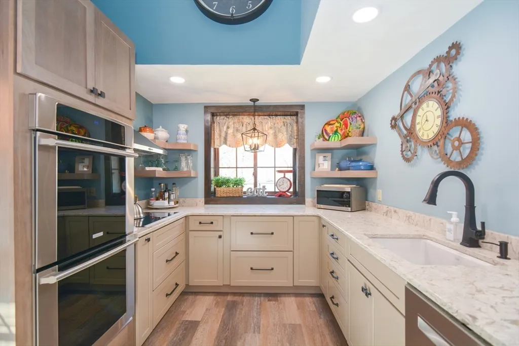 a kitchen with granite countertop stainless steel appliances a sink cabinets and a window