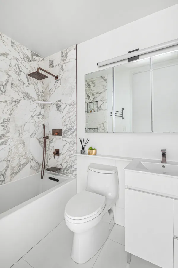 a bathroom with a sink a toilet and shower