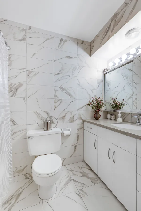 a bathroom with a granite countertop toilet and sink
