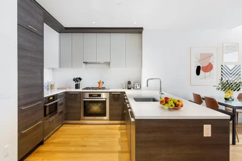 a kitchen with stainless steel appliances a stove a sink dishwasher and cabinets with wooden floor