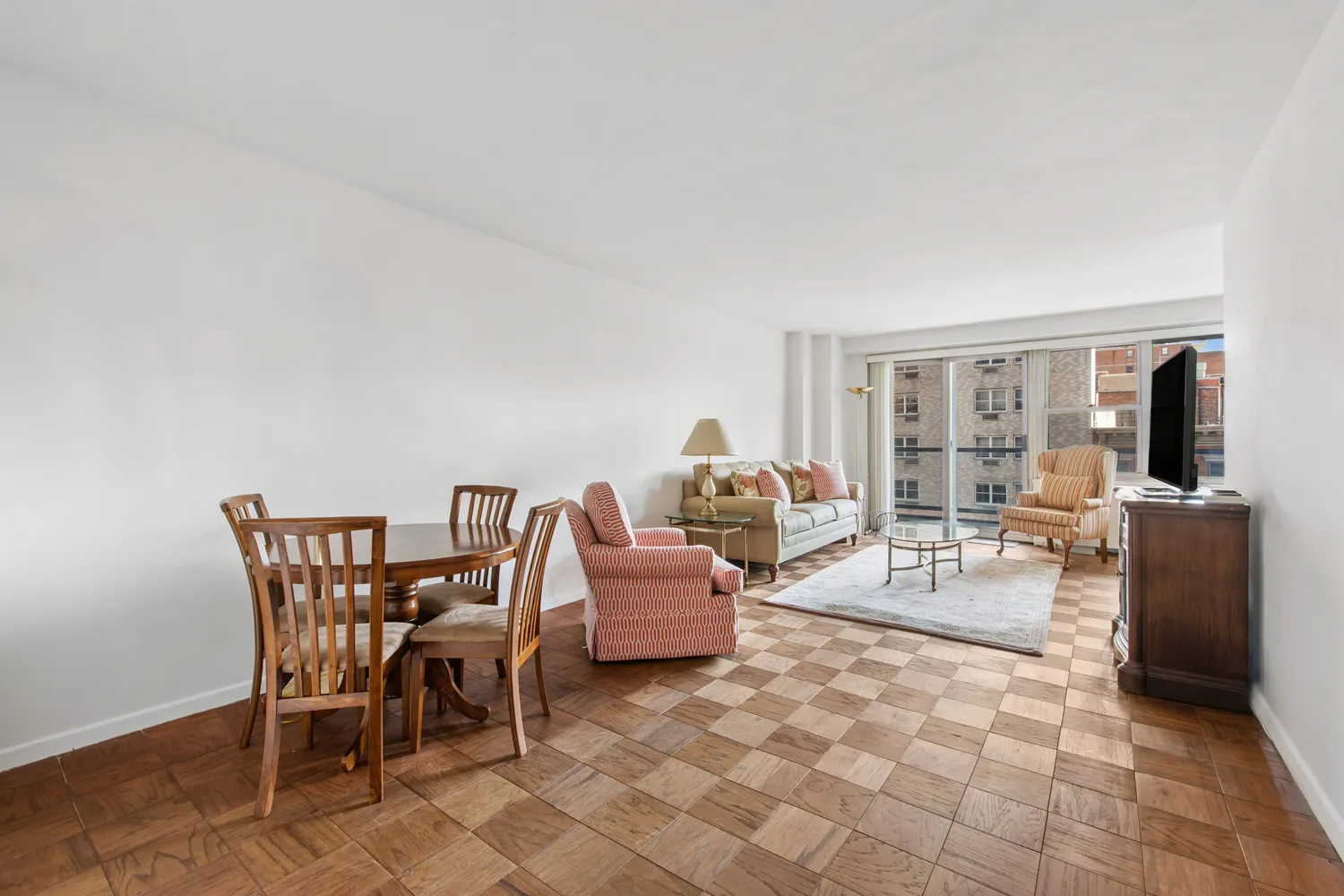 a living room with furniture a flat screen tv and floor to ceiling window