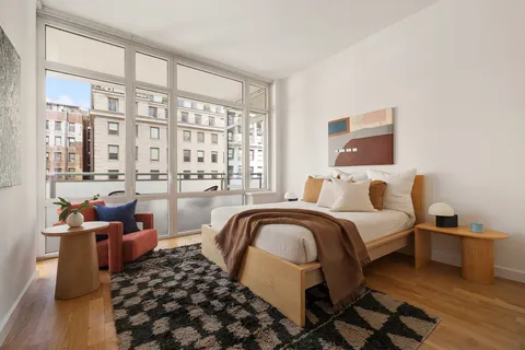 a bedroom with bed and wooden floor
