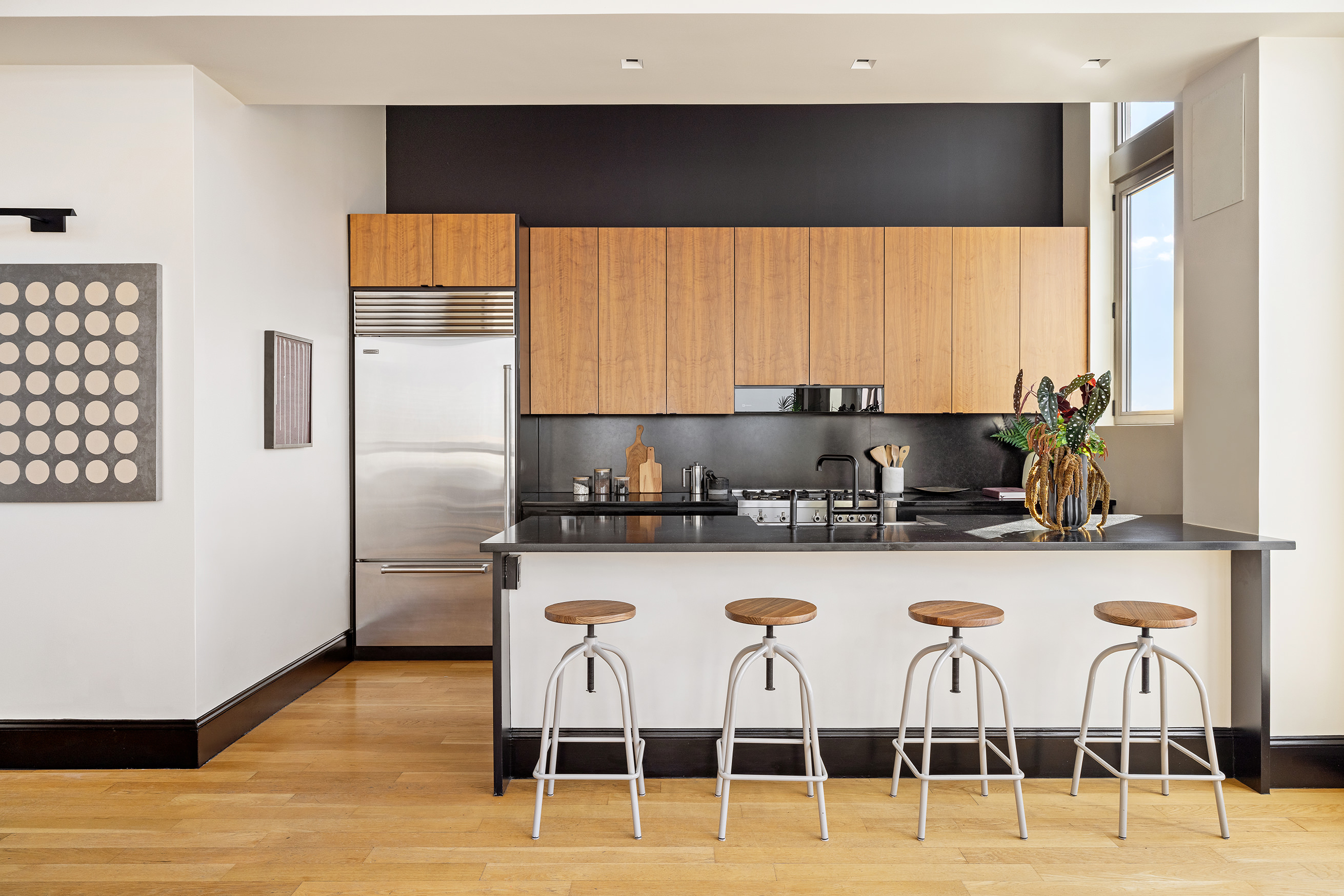 144 North 8th Street, Unit 12A Brooklyn, NY 11249 - Photo 6 of 21 a kitchen with stainless steel appliances a dining table chairs and a refrigerator