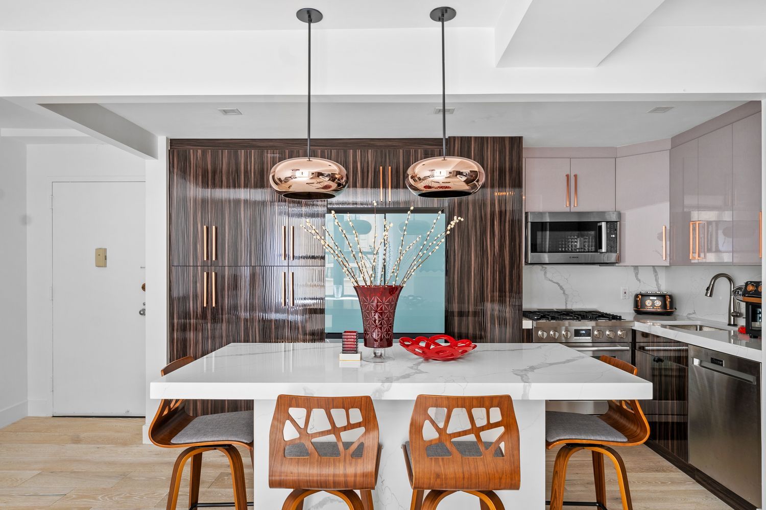 a kitchen with a refrigerator a stove a sink and a dining table with wooden floor