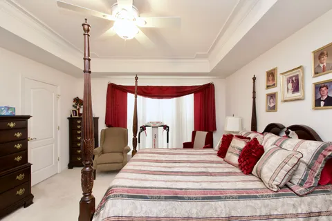 a bedroom with a bed a dresser and chair