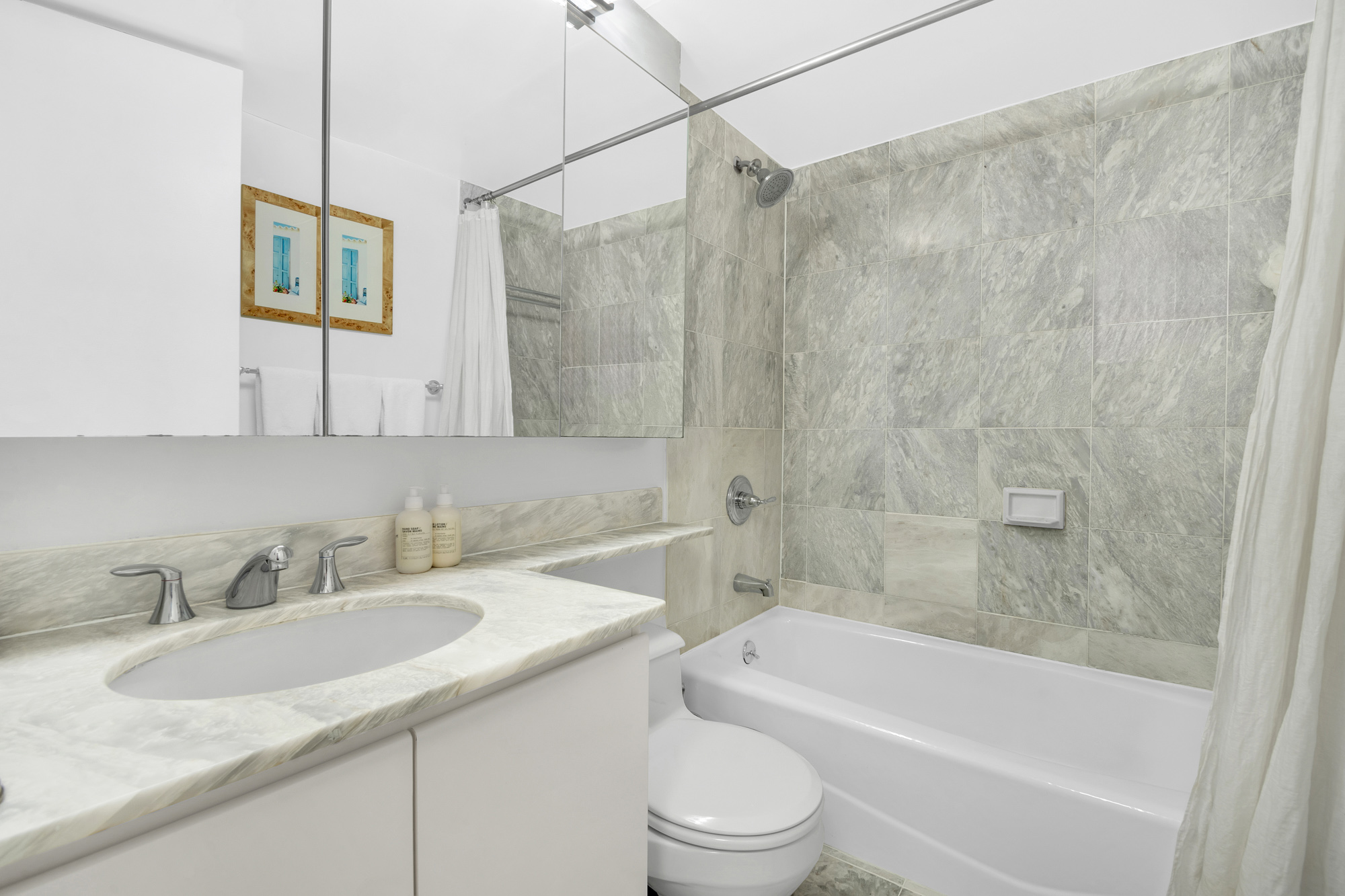 275 Greenwich Street, Unit 11J Manhattan, NY 10007 - Photo 6 of 9 a bathroom with a granite countertop sink toilet and shower