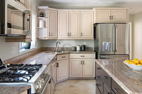 a kitchen with stainless steel appliances granite countertop a stove a sink and a refrigerator