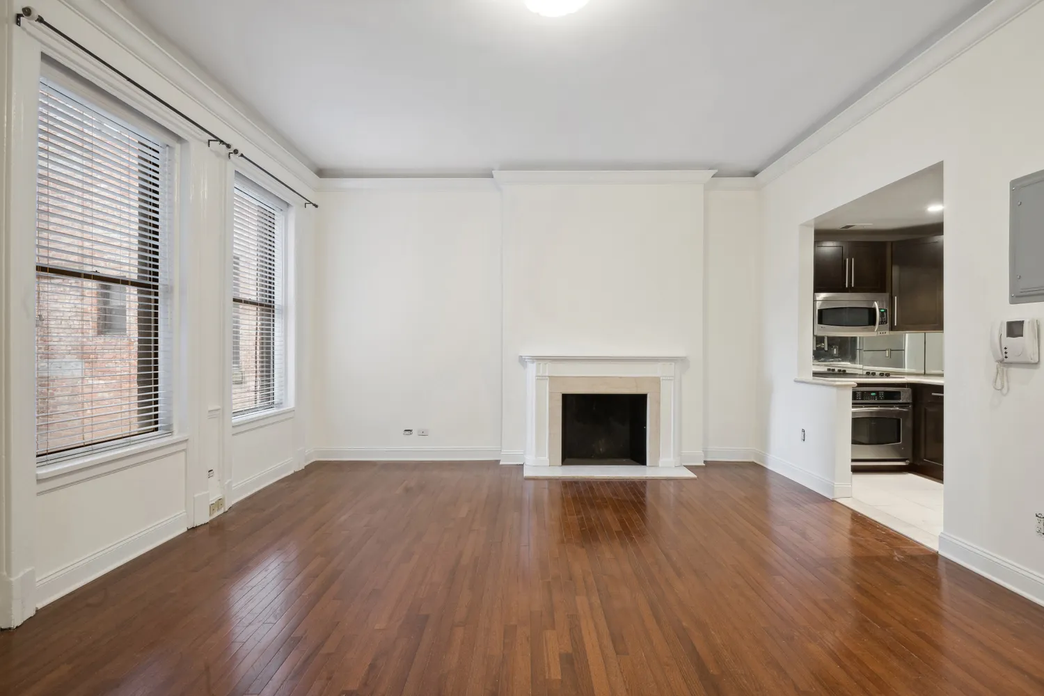 a view of empty room with wooden floor and fireplace