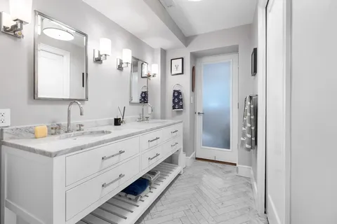 a spacious bathroom with a granite countertop sink and a mirror