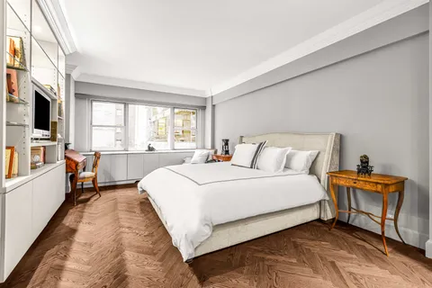 a bedroom with bed and a large window