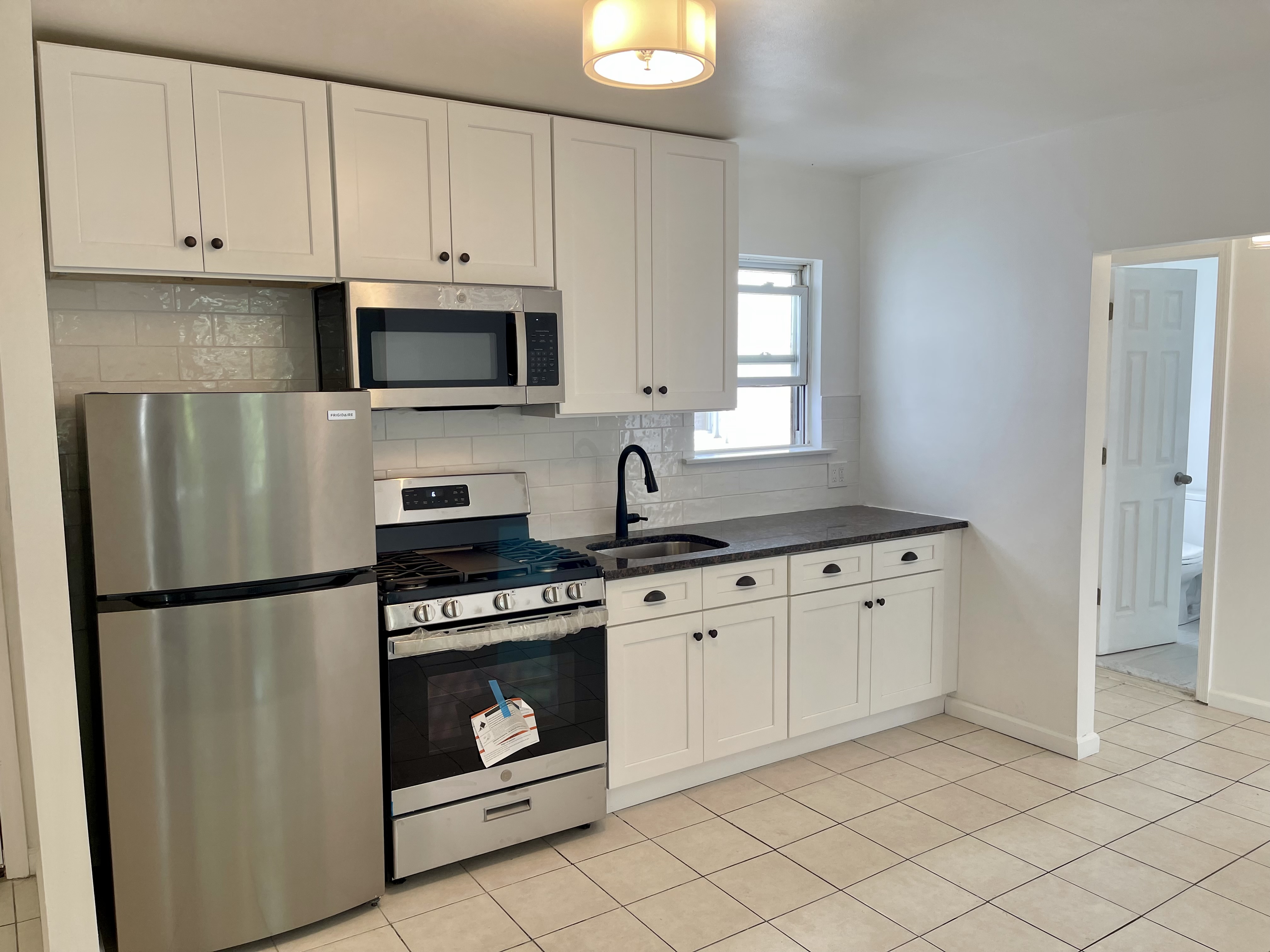 3194 Webster Avenue Bronx, NY 10467 - Photo 7 of 23 a kitchen with granite countertop white cabinets and stainless steel appliances