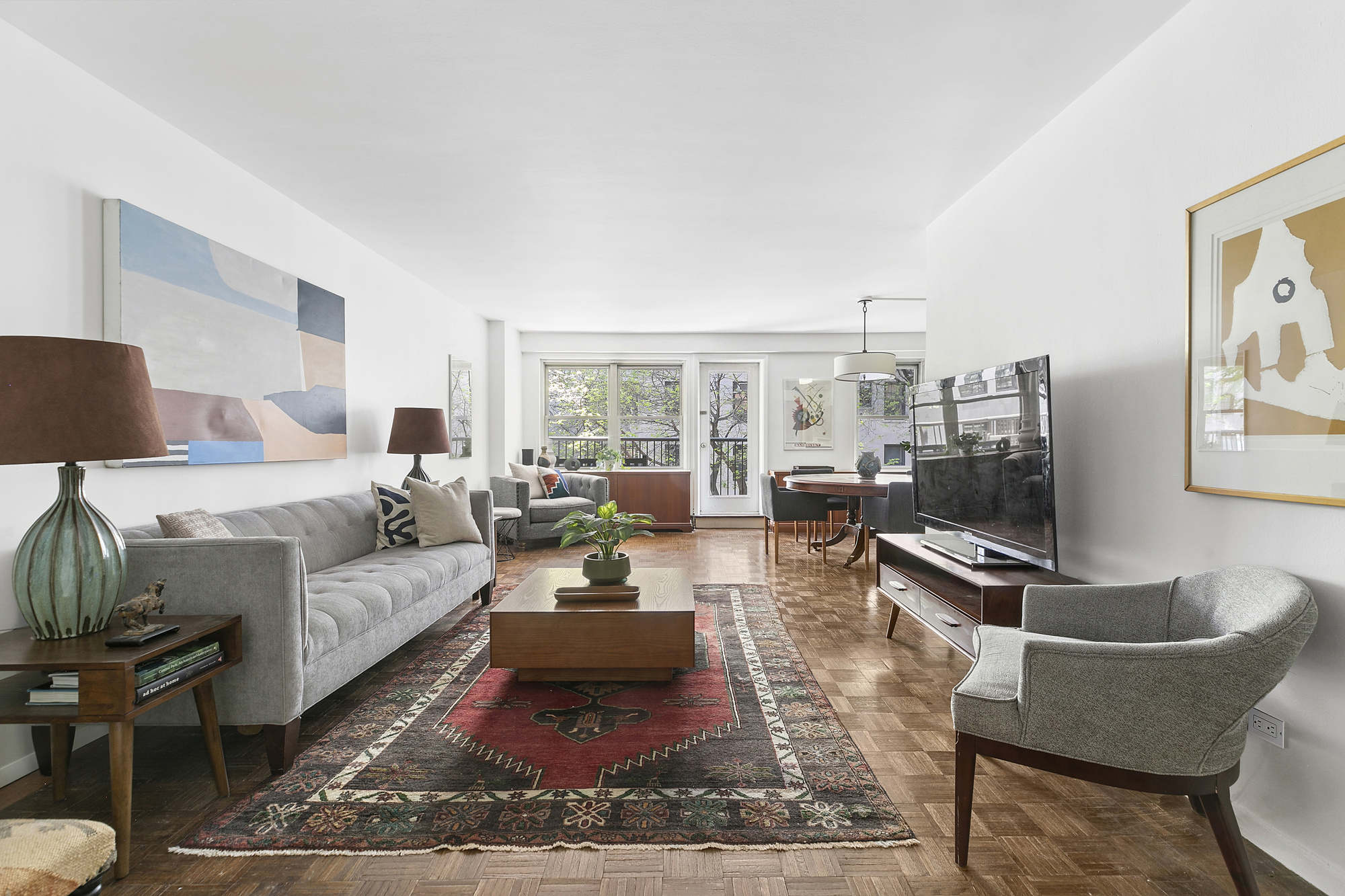 a living room with furniture a rug and a floor to ceiling window