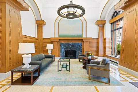 a living room with furniture a fireplace and a large window