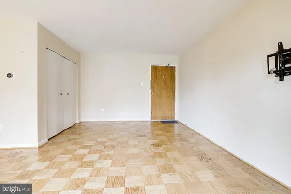 a view of a hallway with wooden floor and a bathroom