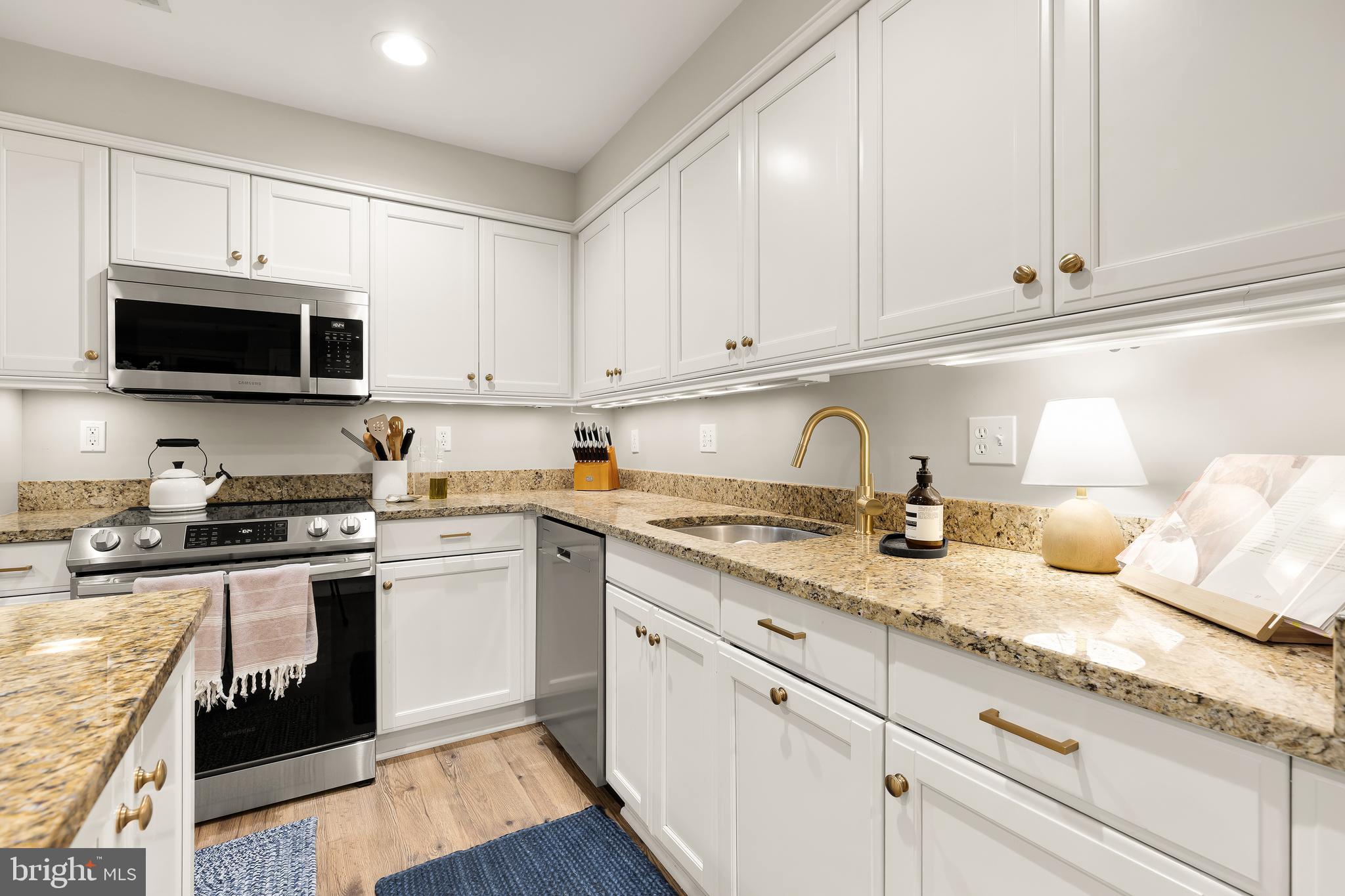 1354 Kenyon Street Northwest, Unit G Washington, DC 20010 - Photo 14 of 37 a kitchen with granite countertop white cabinets and stainless steel appliances