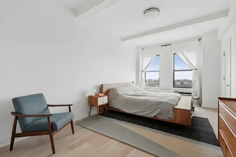 a bedroom with a bed chair and window