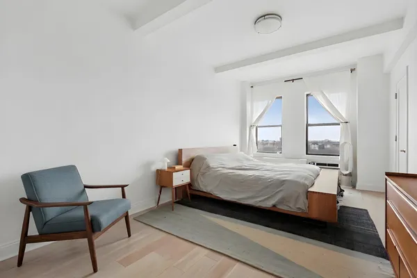 a bedroom with a bed chair and window