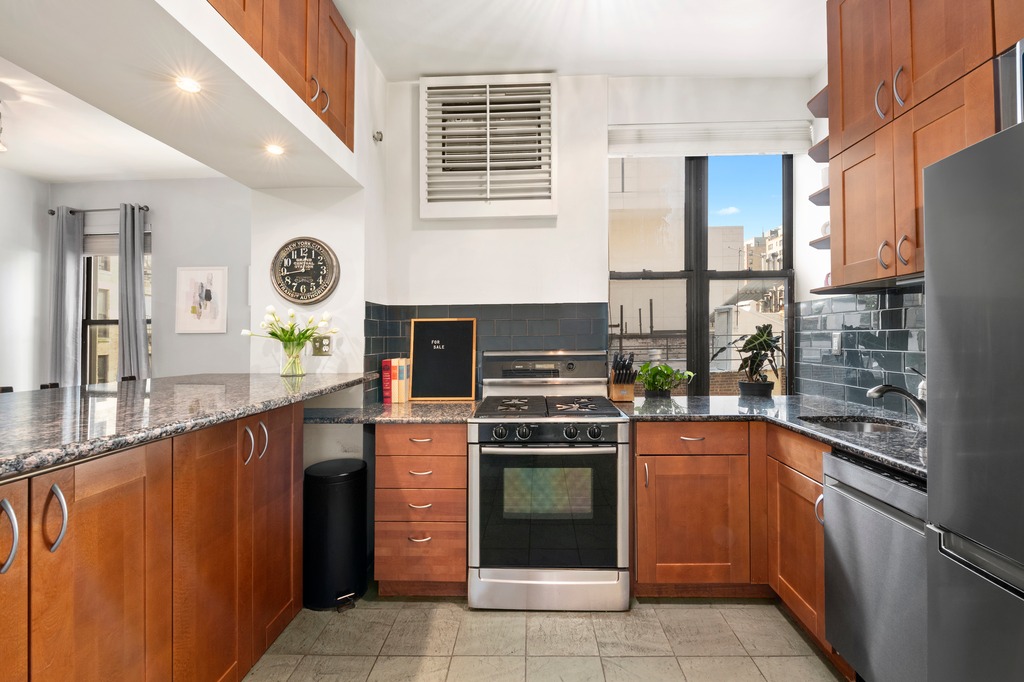 444 East 58th Street, Unit 6C Manhattan, NY 10022 - Photo 5 of 9 a kitchen with stainless steel appliances granite countertop a stove a sink and a refrigerator