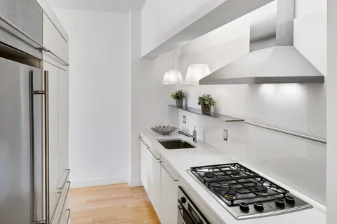 a kitchen with white cabinets and appliances